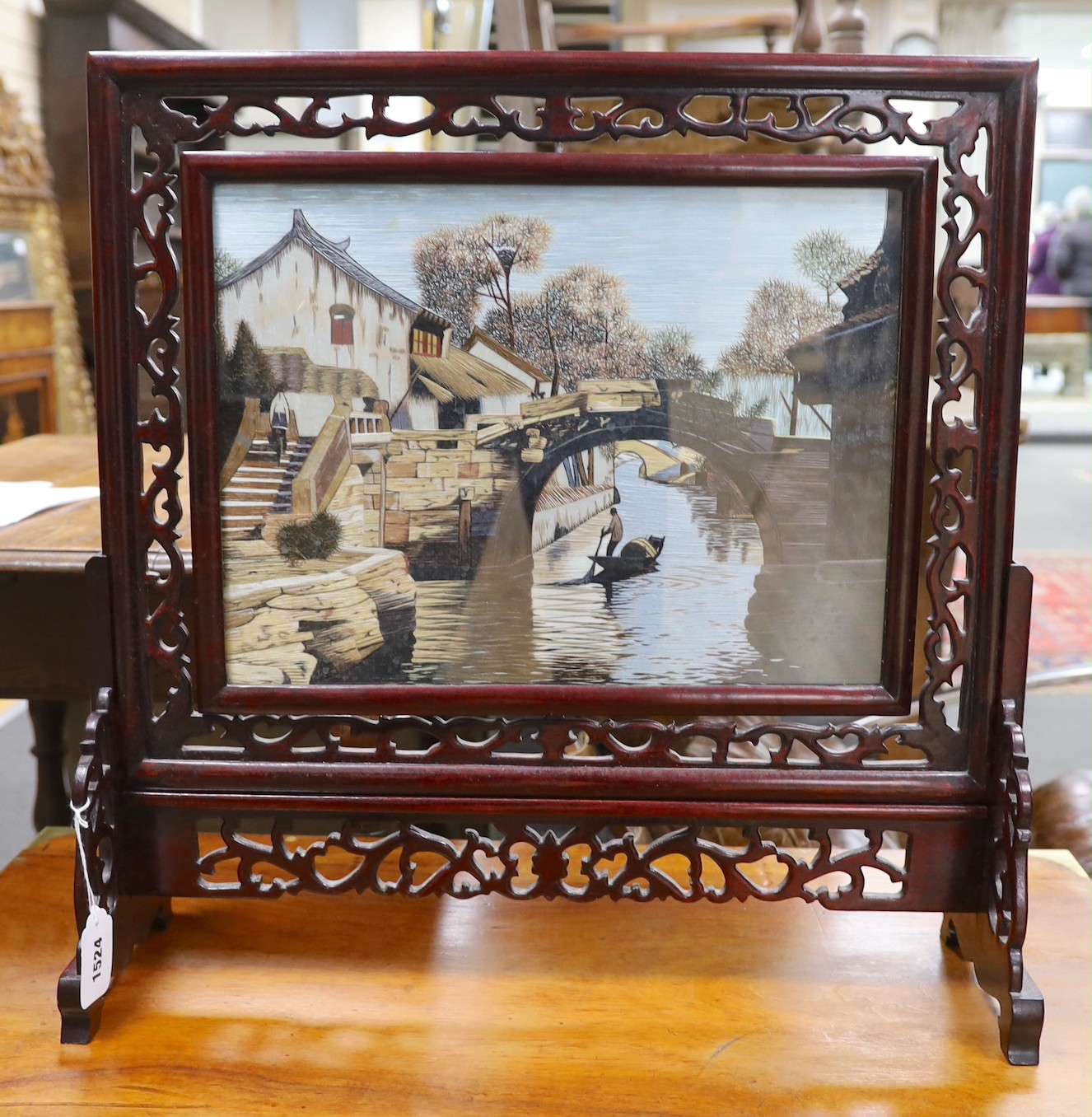 A Chinese hardwood and silk embroidered table screen, with revolving panel 38.5cms wide x 29cms high